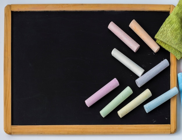 Foto los lápices de colores se colocan en un tablero de dibujo infantil negro con una copia del espacio.