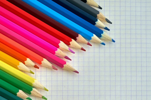 Lápices de colores en un cuaderno comprobado.