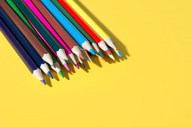 Lápices de colores para dibujar y estudiar en la escuela. Útiles escolares brillantes en amarillo.