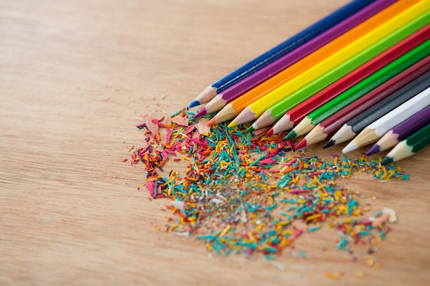 Lápices de colores dispuestos en línea diagonal con virutas de lápiz