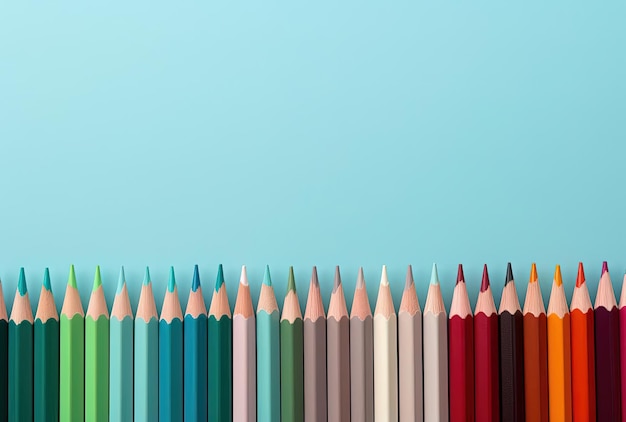 Los lápices de colores están alineados cerca de un fondo azul en el estilo de aguamarina clara y marrón