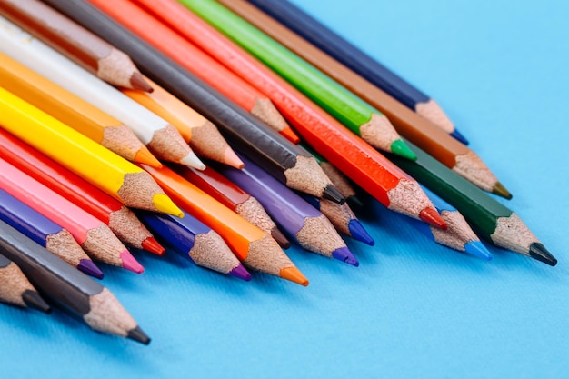 Lápices de colores sobre fondo blanco Herramientas para dibujar educación escuela creatividad Conjunto de lápices de colores sobre un fondo azul.