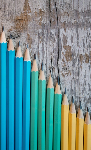 Lápices de colores sobre fondo de madera Vista superior Espacio de copia Lay Flat Concepto de educación de regreso a la escuela