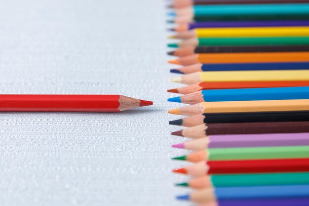 Lápices de colores sobre el fondo de la mesa blancaxA