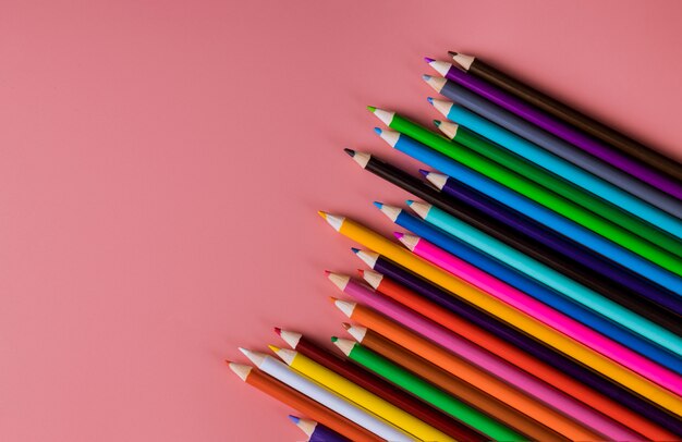 Lápices de colores sobre rosa