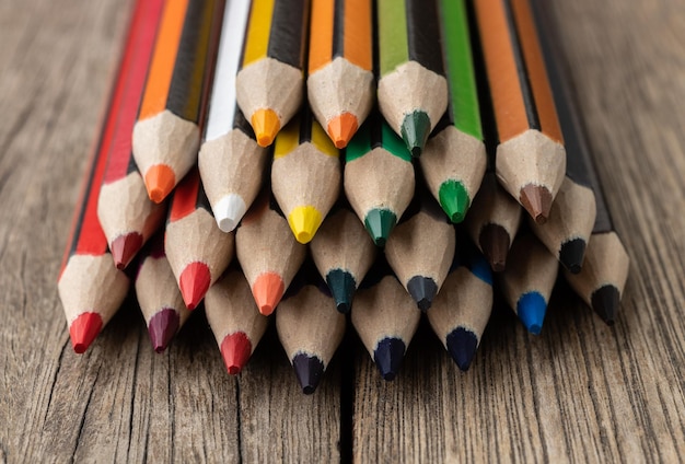 Lápices de colores surtidos sobre mesa de madera.