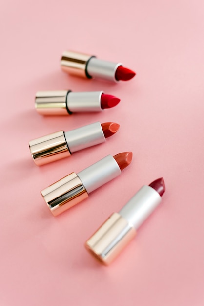 Lápices labiales en diferentes tonos de rosa y rojo. Copyspace, vista superior