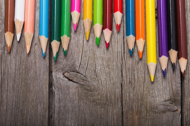 Lápices multicolores en el fondo de madera