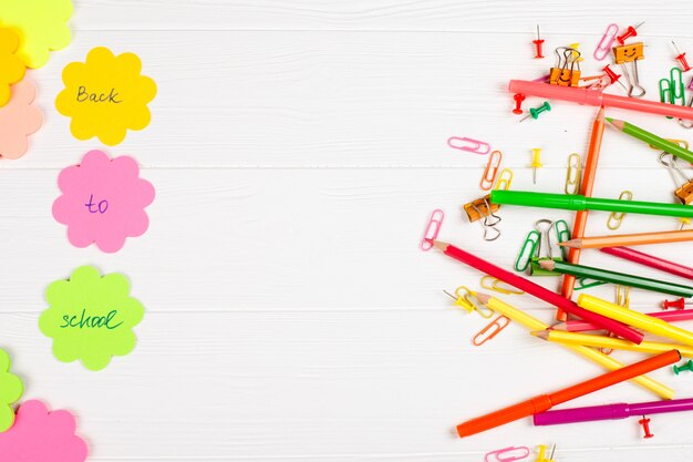 Foto lápices y rotuladores, papel de carta y efectos de escritorio coloridos en el fondo de madera blanco.