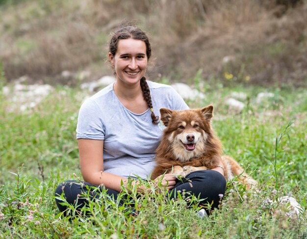 Lapinkoira y la mujer están juntas en la naturaleza.