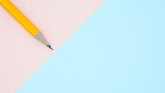 Lápis amarelo em papel azul e rosa