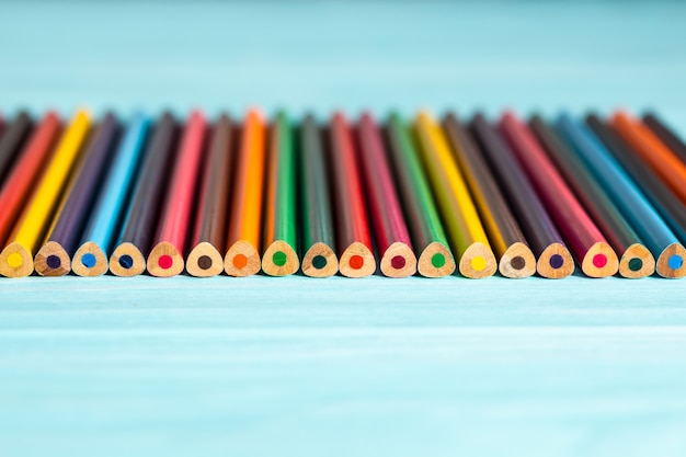 Foto lápis coloridos de todas as cores do arco-íris estão sobre a mesa.