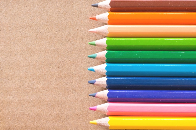 Lápis coloridos no fundo marrom