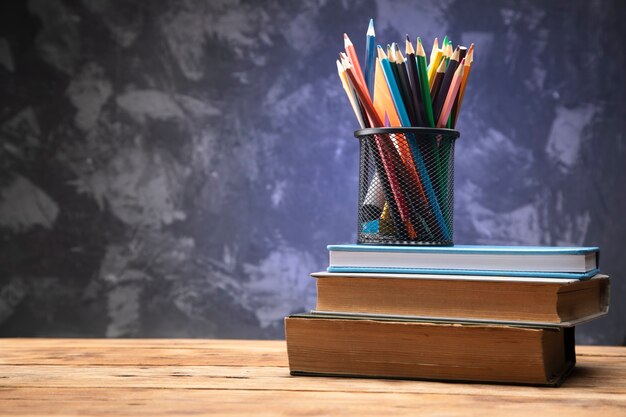 Lápis coloridos nos livros na mesa de madeira