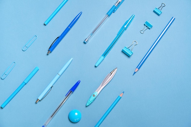 Lápis de canetas compassos de clipes de papel dispostos em linhas todas azuis e de fundo