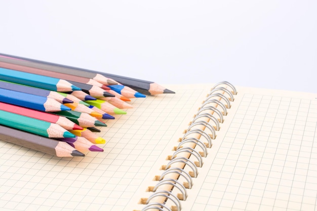 Lápis de cor de várias cores perto de um notebook
