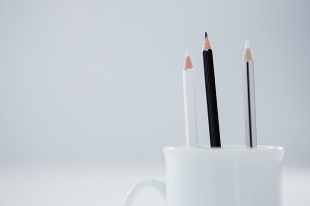 Lápis de cor preto e branco mantidos na caneca