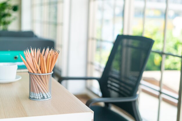 Lápis de madeira em porta-lápis na mesa de trabalho