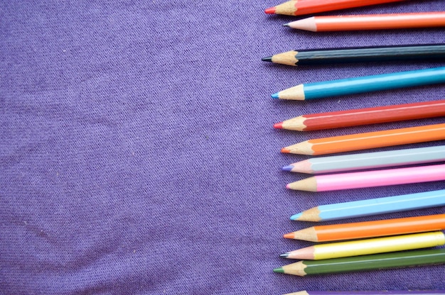 Lápis de madeira heterogêneos multicoloridos para desenhar à direita e um lugar para o seu texto