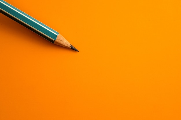 lápiz azul sobre un fondo amarillo anaranjado, concepto de símbolo de idea de innovación creativa