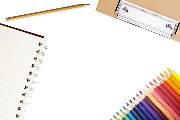 Lápiz de color con cuaderno sobre fondo blanco.