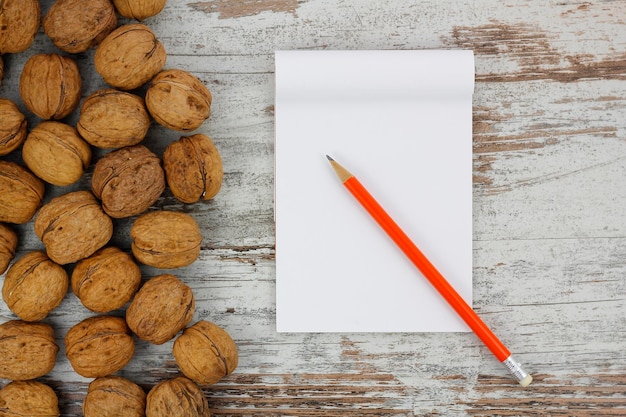 Lápiz de cuaderno blanco y nueces.