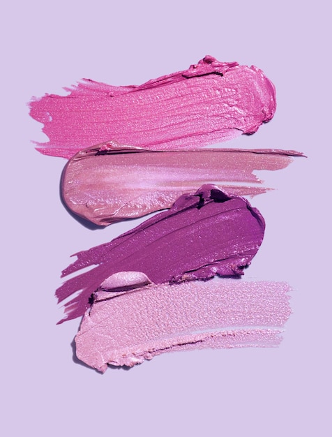 Lápiz labial brillante rosa burdeos púrpura paleta mancha textura de fondo aislado sobre fondo azul