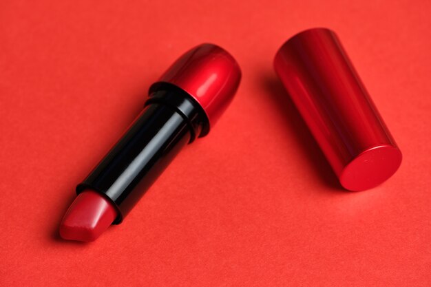 Foto lápiz labial cosmético labios rojos sobre un fondo rojo.