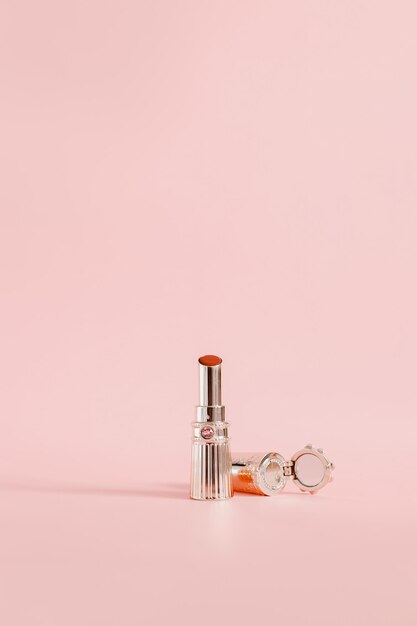 Lápiz labial dorado de lujo color rojo aislado sobre fondo rosa con espacio de copia Fondo de pantalla femenino lindo