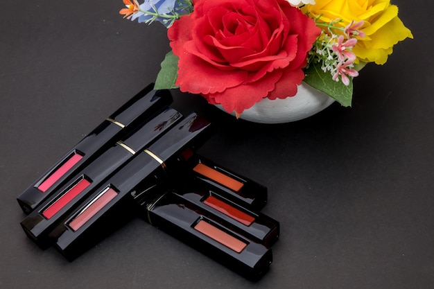 Foto lápiz labial y flores con cosméticos para mujeres