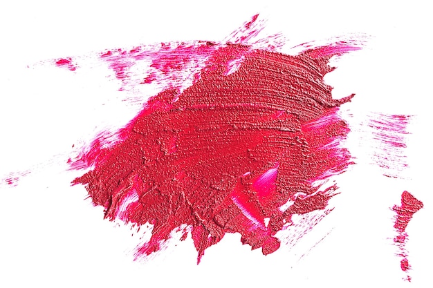 Lápiz labial rojo cremoso en forma líquida, trazos de textura aislados sobre fondo blanco. Concepto de tendencias en cosmética, maquillaje.