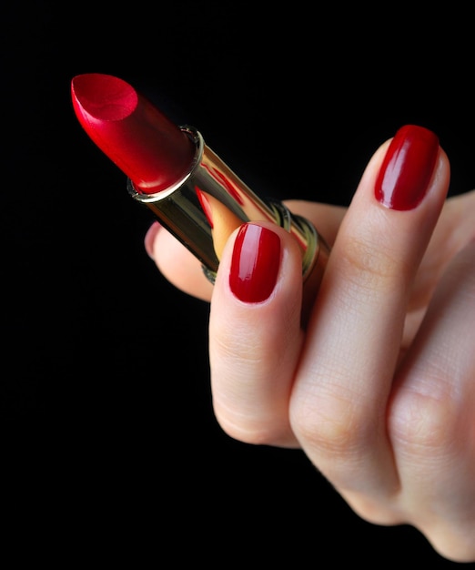 Lápiz labial rojo en mano femenina elegante aislado