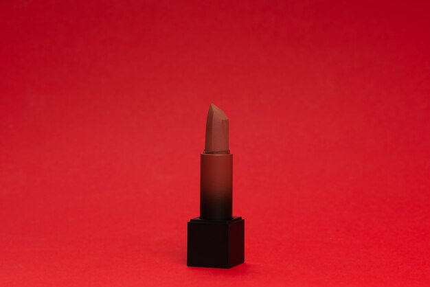 Lápiz labial rojo sobre un fondo rojo. Maquillaje para mujer.