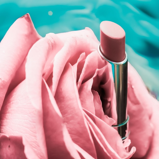 Lápiz labial rosa y flor de rosa sobre fondo líquido maquillaje de glamour a prueba de agua y producto cosmético de brillo de labios para diseño de vacaciones de marca de belleza de lujo