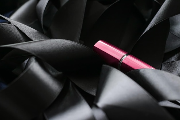 Lápiz labial rosa sobre fondo de seda negra maquillaje de lujo y cosmética de belleza