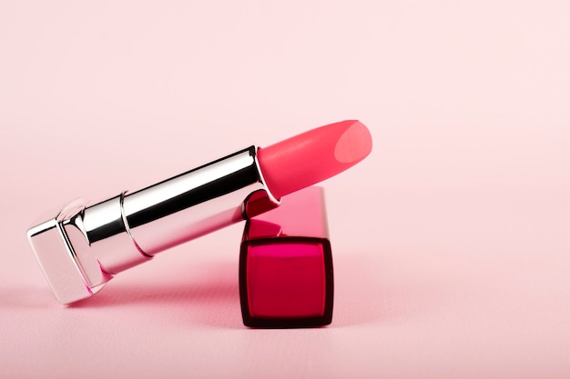 Lápiz labial rosa sobre una mesa rosa. Maquillaje de labios