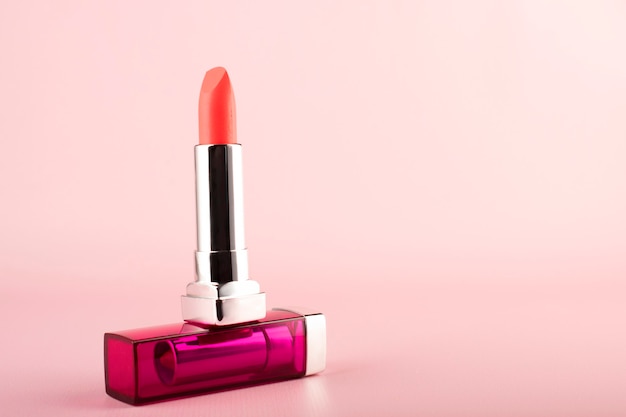 Lápiz labial rosa sobre una mesa rosa. Maquillaje de labios