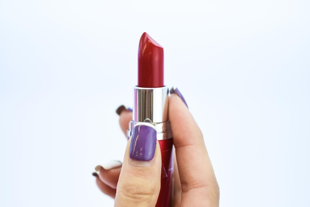 Lápiz labial suave que incluye bálsamo Lápiz labial para maquillaje profesional Maquillaje diario Concepto de cuidado de labios Lápiz labial sobre fondo blanco Producto de lápiz labial de alta calidad en mano femenina Debe tener tendencia de belleza