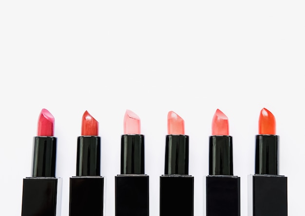 Lápiz labial de varios colores dispuestos en filas sobre un fondo blanco