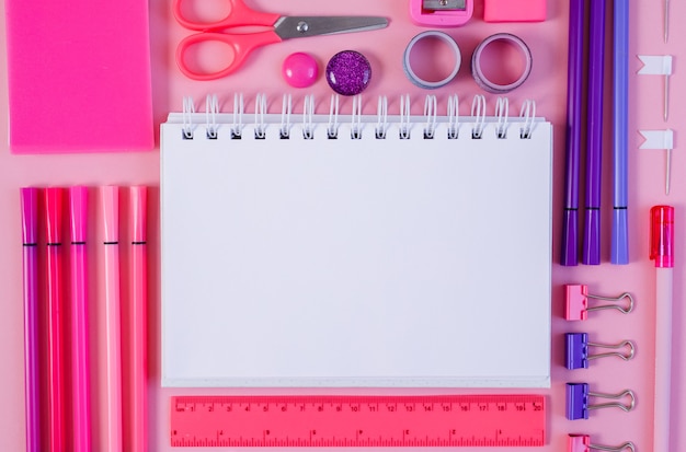 Lápiz y marcador de bloc de notas rosa sobre fondo rosa endecha plana