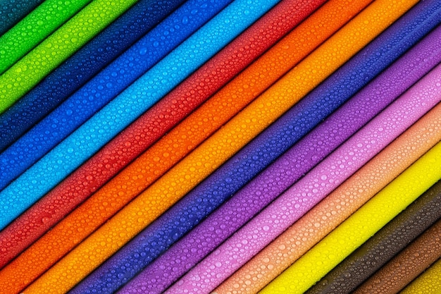 Foto lápiz multicolor con gotas de agua en la mesa de madera vista de enfoque selectivo