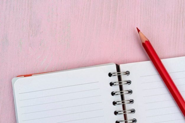 Lápiz rojo y cuaderno de notas.