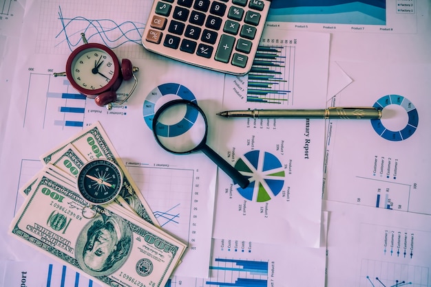 Foto lápiz en la tabla del diagrama y el informe de negocios de los gráficos con el dinero, compás, calculadora en el escritorio del consejero financiero. concepto de planificación financiera y contable. vista superior.