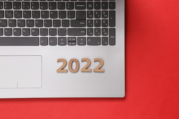 Laptop con 2022 sobre fondo rojo Composición de año nuevo