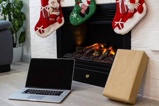 Laptop am Weihnachtskamin mit Dekoration von Socken. Nahansicht.