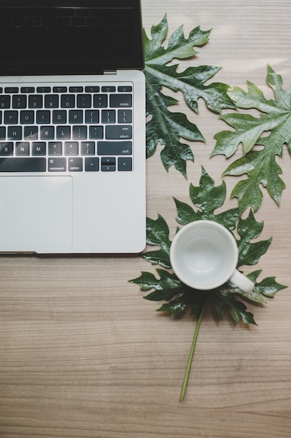 Laptop auf einem Holztisch und einem Tasse Kaffee