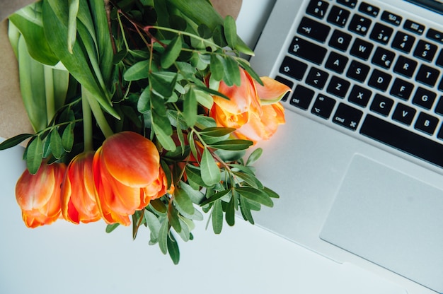 Laptop auf weißem Boden mit Blumen