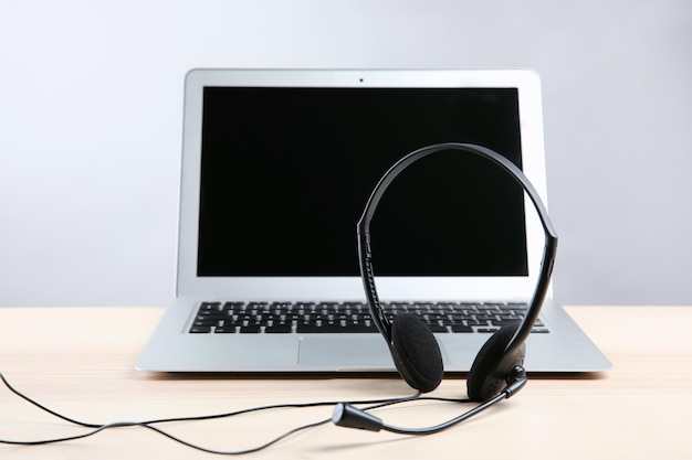 Foto laptop con auriculares en mesa blanca