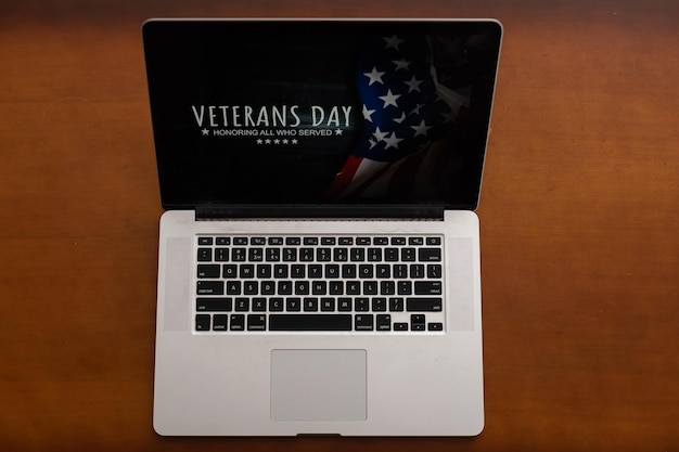 Laptop con bandera de estados unidos e inscripción día de los veteranos.