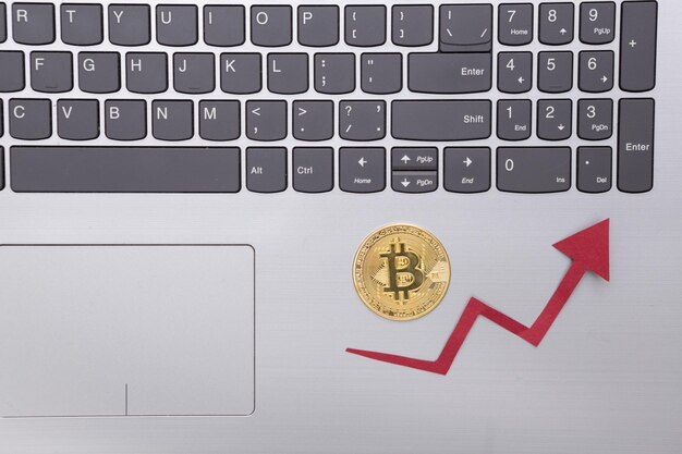 Laptop Bitcoin y flecha de crecimiento sobre fondo gris Criptomoneda El aumento en el valor de bitcoin